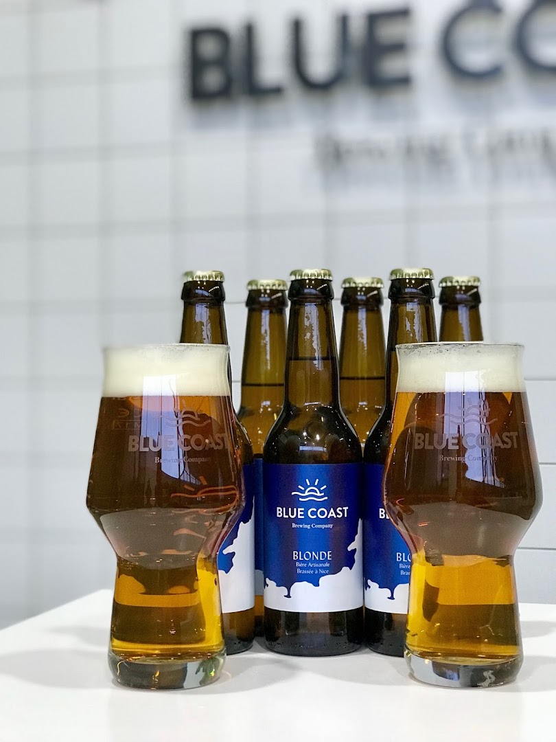 Des bouteilles de bière alignées derrière deux verres